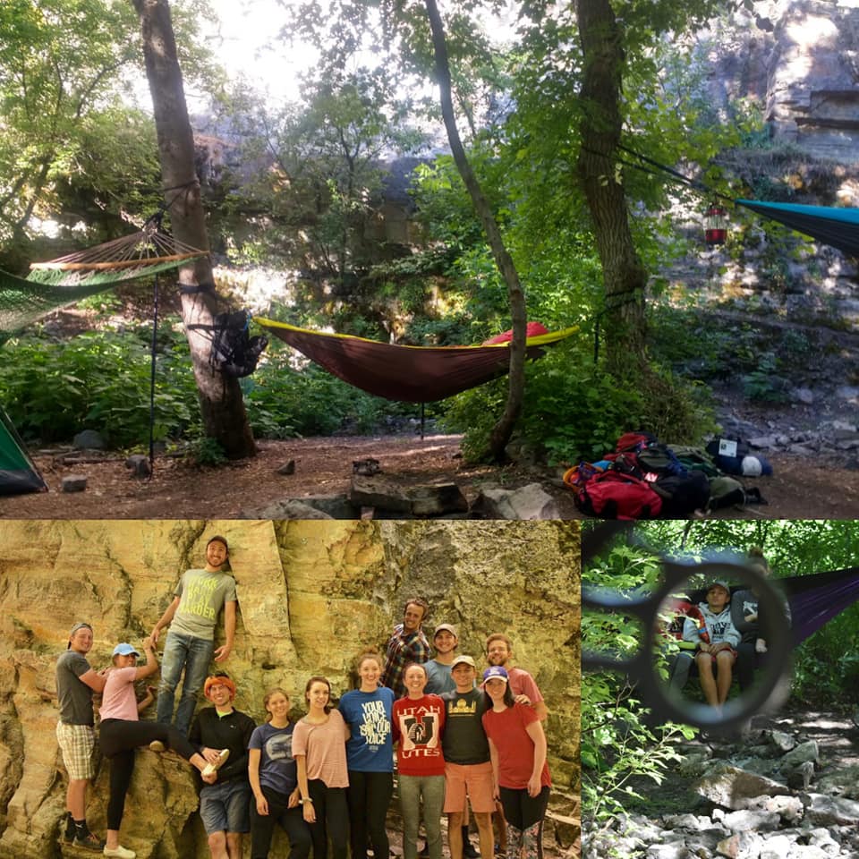 Hammocks strung between trees and a group posing by a rock wall
